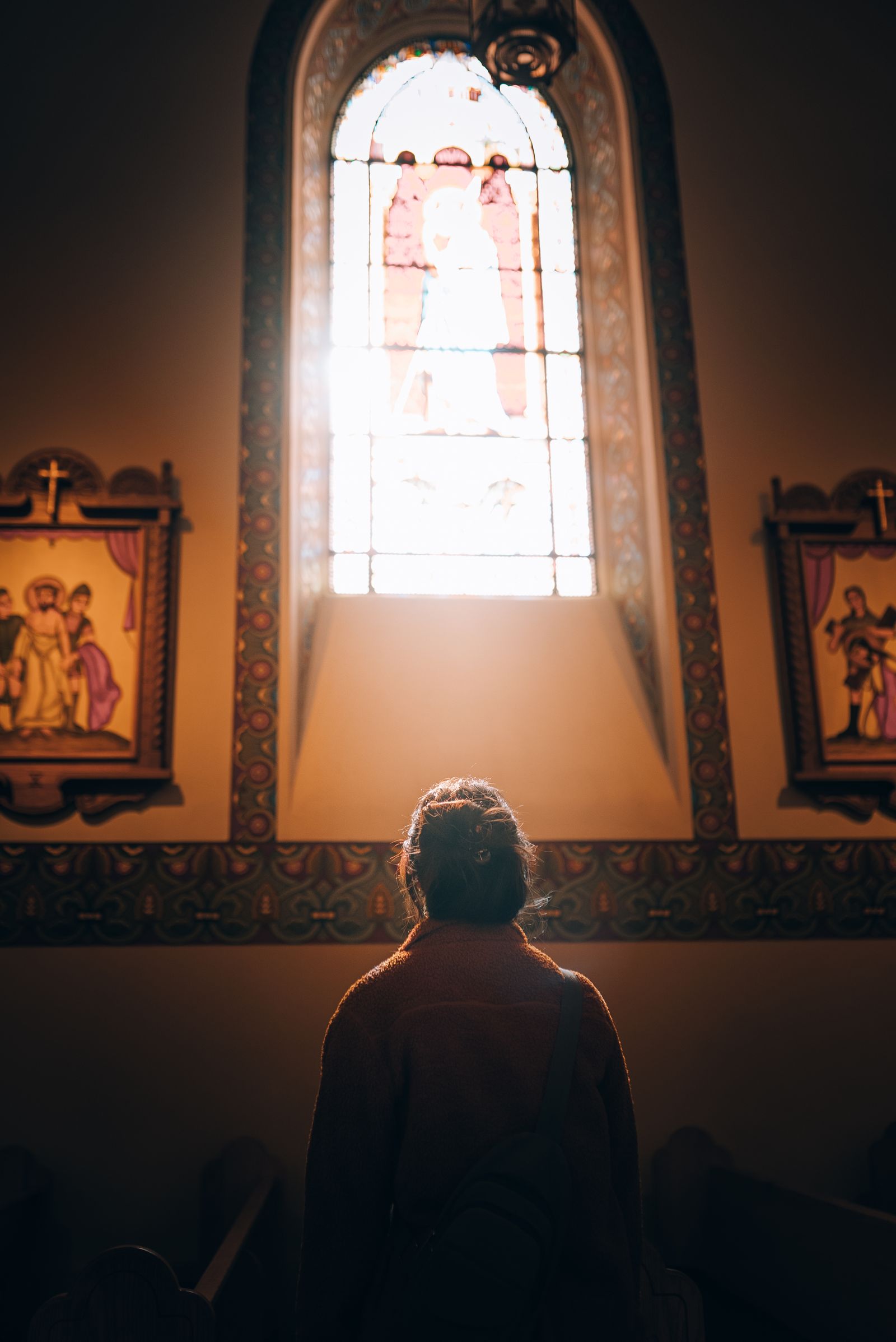 A woman standing before a church window